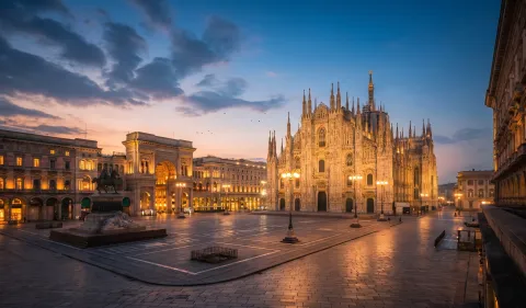 Piazza del Duomo in Milan at dusk with the illuminated cathedral and Galleria Vittorio Emanuele II