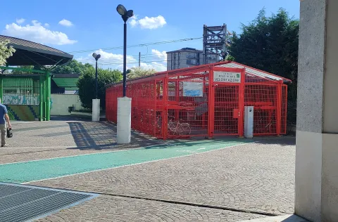 Velostazione recintata di colore rosso alla stazione di Novate Milanese