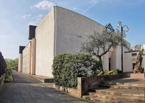 Edificio moderno con sagrato pietroso e albero di ulivo a Sesto San Giovanni.
