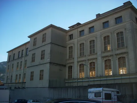 Edificio storico a Rovereto con grandi finestre ad arco sulla facciata.