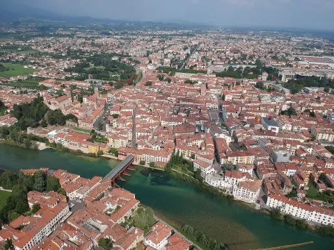 Aerial view of Bassano del Grappa featuring the famous Ponte degli Alpini over the Brenta River.