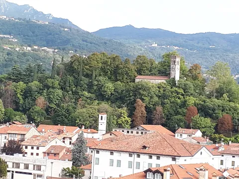 Panoramic view of Schio showing red roofs and the landmark Castle tower on a green hill