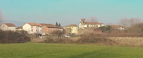 Vista panoramica dei campi e del centro abitato di Capannori con campanile in cotto e colline lucchesi