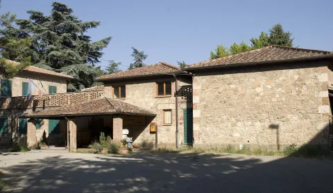 Stone building with a porch and green shutters in Poggibonsi, Tuscany