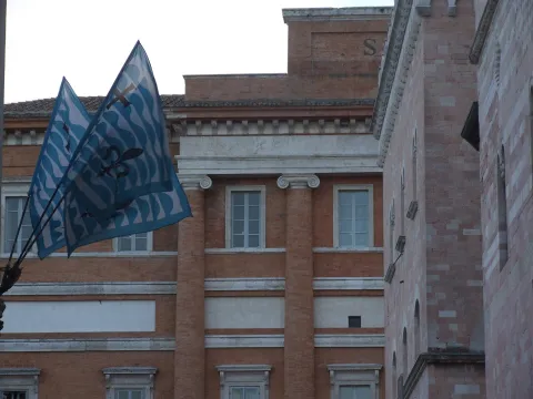 Bandiere rionali sventolano davanti al Palazzo Comunale in Piazza della Repubblica a Foligno.