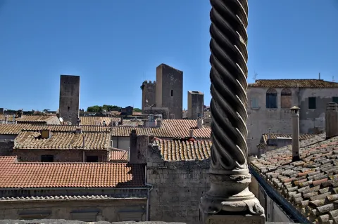 Panorama dei tetti e delle torri medievali di Tarquinia inquadrato da una colonna tortile.