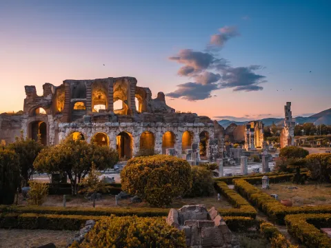 Tramonto con nuvole scure e sfumature arancioni sullo skyline di Santa Maria Capua Vetere.