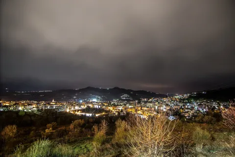 Veduta panoramica notturna della città di Teramo sotto un cielo nuvoloso.