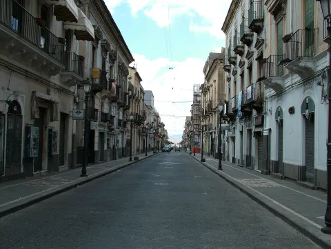 View of a historic street in the town of Adrano with period buildings