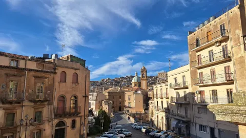 View of the historic center of Caltagirone in Sicily with a church dome in the background.