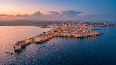 Historic mill house perched on the rocks above the Greek Theatre of Siracusa.
