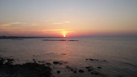 Sunset over the sea along the rocky coast of Bisceglie in Puglia