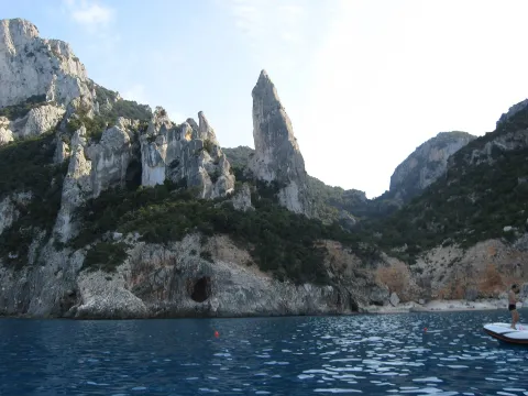The iconic limestone pinnacle at Cala Goloritzé in Baunei, Sardinia, seen from the sea.