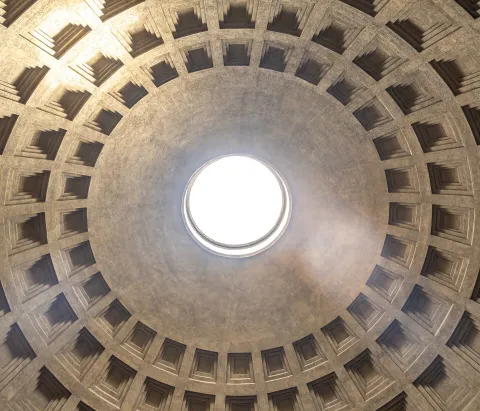 View from below of the coffered dome and central oculus of the Pantheon in Rome.
