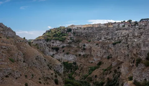 View of the Sassi di Matera perched on the edge of the rocky Gravina canyon