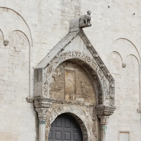 Dettaglio del portale romanico della Basilica di San Nicola a Bari con scultura in cima
