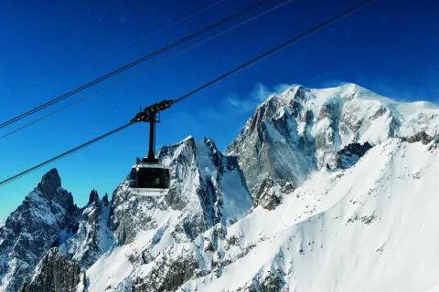 Skyway Monte Bianco cable car cabin suspended over snowy alpine peaks in Courmayeur