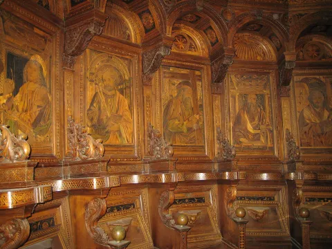 Stalli in legno intarsiato del coro della Certosa di Pavia, decorati con figure di santi.