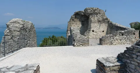 Ancient Roman ruins of the Grotte di Catullo in Sirmione with Lake Garda in the background.