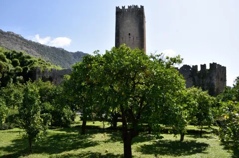 Medieval tower at the Garden of Ninfa amidst citrus trees in Cisterna di Latina