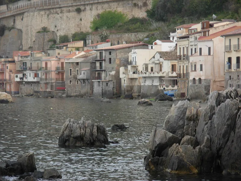 Scorcio di Chianalea a Scilla con le storiche case affacciate direttamente sul mare e scogli.