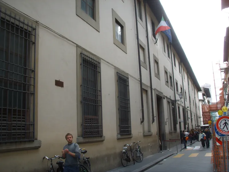 Exterior facade of the Galleria dell'Accademia in Florence with visitors queuing on Via Ricasoli.